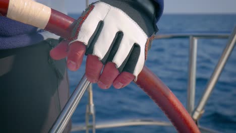 Extreme-close-up-of-sailor-controlling-the-direction-of-sailboat-with-steering-wheel