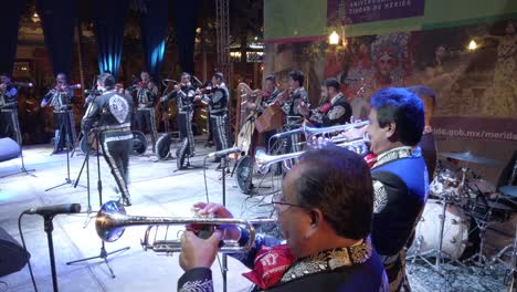 Wide-angle-shot-of-Mariachi-band-on-stage-outside-at-night-during-Merida-Fest-in-Merida,-Mexico