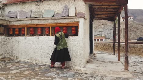 An-Old-Woman-walking-and-turning-the-Prayer-wheels-in-Lamayuru-Monastery
