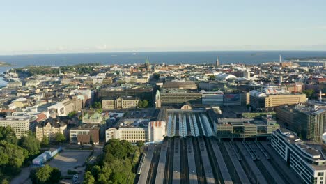 Slow-aerial-pan-of-large-buildings-in-Helsinki,-Finland-with-ocean-in-distance