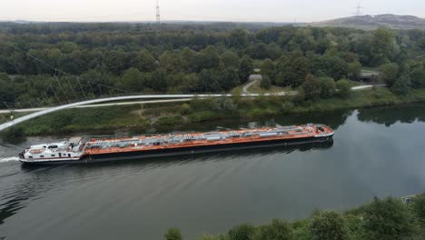 Aerial-pan-of-tanker-barge-navigating-up-the-Rhine-Herne-Canal,-Germany