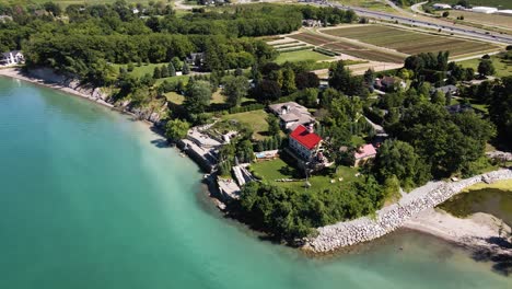 Aerial-view-of-a-luxury-private-house-estate-on-the-lakefront-of-an-emerald-lake