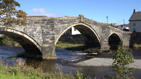 smooth-zoom-shot-of-an-old-bridge-in-a-welsh-town-with-a-river-flowing-beneath