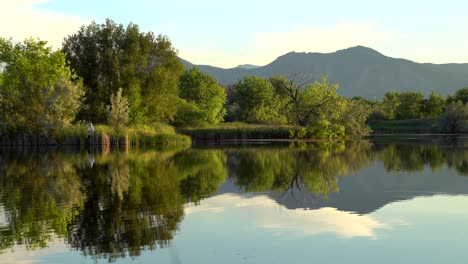 Hombre-Pescando-En-Un-Lago-Con-Hermosas-Vistas-A-La-Montaña-Y-Reflexión