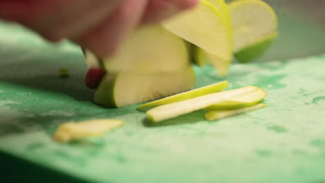 Chef-Slicing-Fresh-Green-Apple-On-The-Chopping-Board-In-The-Restaurant-Kitchen---slow-motion