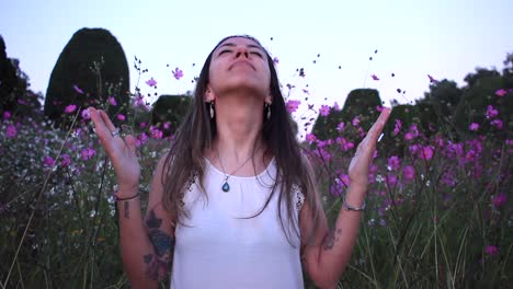 young-latin-woman-grateful-with-god-in-the-middle-of-a-beautiful-purple-field-with-tinny-flowers