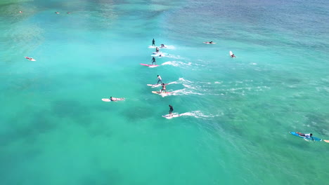 Surfistas-En-Una-Línea-Montando-Las-Olas-De-La-Playa-De-Waikiki,-Honolulu,-Hawaii
