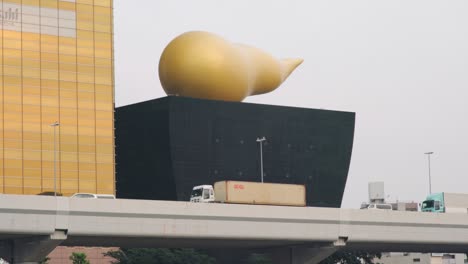 Riesige-Goldene-Poop-Struktur-In-Der-Asahi-Bierhalle-Mit-Vorbeifahrenden-Fahrzeugen-über-Den-Sumida-Fluss-In-Asakusa,-Tokio-–-Totalaufnahme
