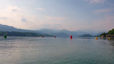 Zwei-Athleten-Paddeln-Auf-Kanus-Zwischen-Bojen-In-Richtung-Zentrum-Des-Orta-Sees