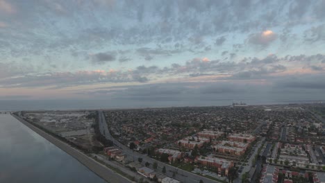 Stunning-4K-UHD-aerial-sunrise-over-an-urban-cityscape-with-a-river-and-colorful-clouds