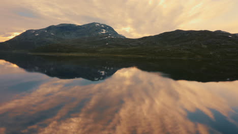 Herrlicher-Sonnenuntergang-Im-Vavatn-See-In-Hemsedal-Mit-Wunderschöner-Bergspiegelung-Vor-Bewölktem-Himmel-–-Weitwinkelaufnahme