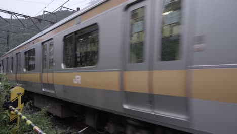 Jr.-Chuo-Zug-In-Tokio,-Japan,-Der-Durch-Ländliche-Landschaft-Fährt---Blick-Von-Der-Nähe-Des-Bahnübergangs