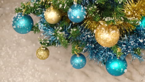 Snow-falling-on-Christmas-tree-with-golden-balls