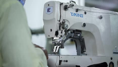 Sweatshop-Worker-Operating-Sewing-Machine-In-Designer-Clothing-Manufacturing-Factory