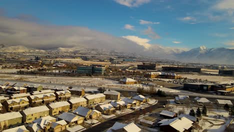 Silicon-Slopes-in-Lehi,-Utah-on-a-winter-day-with-a-fresh-layer-of-snow-over-the-city---aerial-parallax-panoramic-view