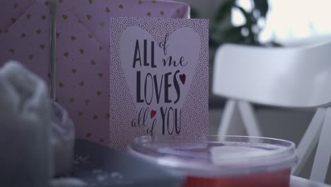 Valentinskarte-Mit-Rosa-Verpacktem-Geschenk-Und-Süßigkeiten,-Handheld-Nahaufnahme-Mit-Geringer-Schärfentiefe