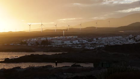 A-spectacular-sunset-over-The-Abades-town-with-the-turbines-in-the-distance,-Tenerife