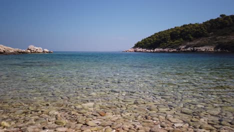 View-of-shimmering-clear-waters-and-smooth-pebbles-of-Svitnja-beach-on-the-island-of-Vis-in-Croatia