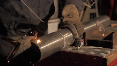 Welder-testing-shield-arc-welding-electrode-flux-rod-before-welding-stainless-steel-pipe