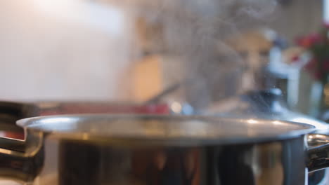 Dampf-Steigt-über-Einem-Glänzenden-Topf-In-Einer-Heimischen-Küche-Auf,-Während-Das-Wasser-Zu-Kochen-Beginnt