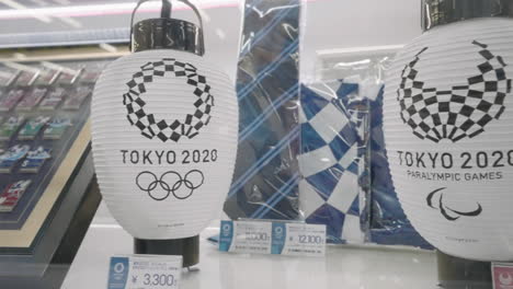 Weiße-Japanische-Papierlaternen-Mit-Dem-Logo-Der-Paralympischen-Spiele-2020-In-Tokio-Werden-Während-Der-Pandemie-In-Tokio,-Japan,-Auf-Einem-Regal-Im-Offiziellen-Olympischen-Laden-In-Tokio-Ausgestellt
