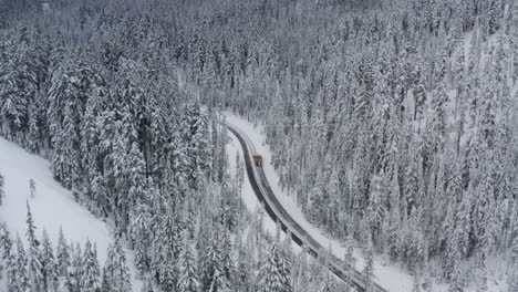 A-snow-plow-clears-a-road-in-the-middle-of-a-forest
