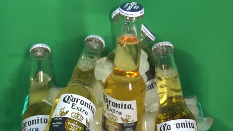 1-2-Coronita-Corona-Extra-Beer-6-pack-of-Small-Glass-Bottles-of-200ml-in-chilled-stack-of-ice-bucket-cooler-Rotating-180-degree-in-front-of-a-green-screen-for-a-cool-refreshing-taste-to-cool-off