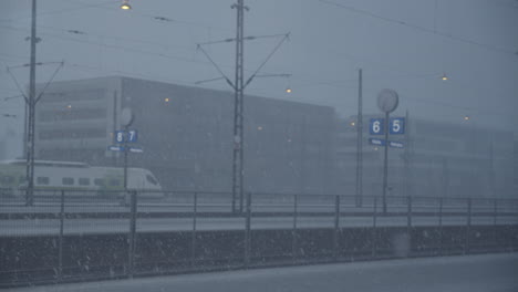 Static-wide-shot-of-Helsinki-Train-Station-with-large-building-in-background-during-snow-winter-day