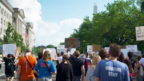 Demonstranten-Halten-BLM-Schilder-In-Der-Hand,-Während-Sie-Am-Washington-Monument-Vorbeikommen