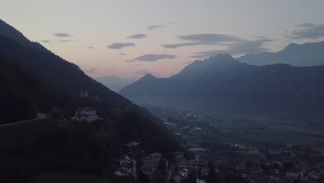 Aerial-view-of-Levico-Terme,-Italy-,-during-sunrise-with-drone-descending