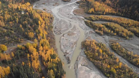 Drone-Volando-A-Través-Del-Lago-Glaciar-Plateado-Entre-Bosques-De-Otoño-De-Montañas-Nevadas-En-Alaska