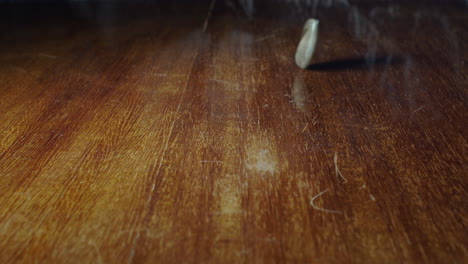 Closeup-of-1-Spanish-peseta-flipping-on-wooden-table,-static,-slow