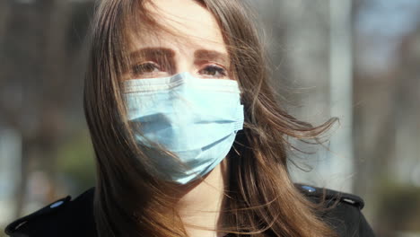 Portrait-of-Girl-With-a-Face-Mask-and-Sad-Eyes-Walking,-Looking-at-Camera,-Close-Up-Slow-Motion
