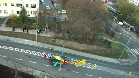 Helikopter-Rettung,-Ein-Rettungshubschrauber-Steht-Mitten-Auf-Der-Straße-In-Der-Stadt,-Eine-Menschenmenge-Steht-Herum
