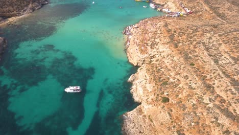 Blue-Lagoon,-seen-from-high-overhead,-with-clear-warm-water-and-coral-visible-beneath-the-surface-is-a-popular-Mediterranean-holiday-destination-for-visitors