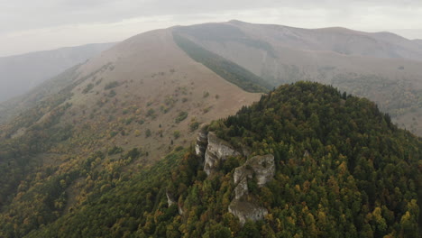 Aerial-shot-of-rock-formation-on-autumn-forest-peak,-Slovakia