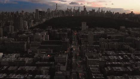 Drohnenaufnahmen-Des-Sonnenuntergangs-In-Harlem,-New-York-City,-Mit-Blick-Auf-Den-Central-Park-Und-Blick-Auf-Die-Straße
