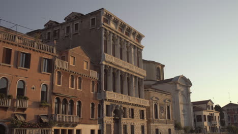 Tilt-up-shot-of-Historic-Palazzo-Flangini-Facade-lit-by-Morning-sunrise,-Venice,-Italy