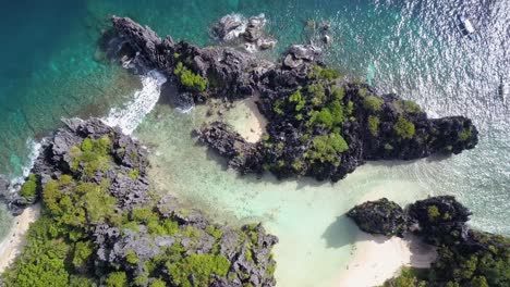 Aerial-pedestal-down-on-Hidden-Beach-and-clear-shallow-waters-surrounded-by-limestone-cliffs-in-El-Nido,-Palawan,-the-Philippines