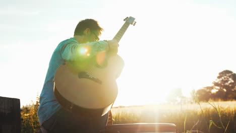 Musician-takes-guitar-out-of-case-at-sunset-slow-motion