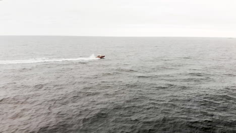 Aerial-shot-of-one-lone-motor-boat-speeding-through-the-endless-waves-of-the-open-ocean