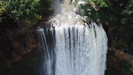 Drone-moving-backwards-to-show-the-size-of-a-waterfall