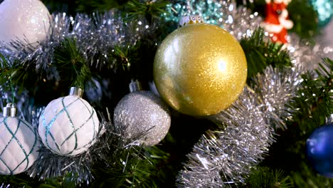 Panning-shot-of-decorative-ornaments---tinsel-on-a-Christmas-Tree