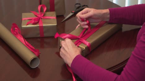 Closeup-Hands-Tying-Red-Ribbon-on-Christmas-Gifts