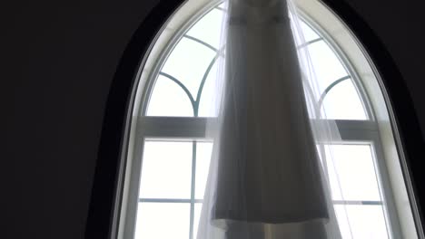 Upward-angled-slider-shot-of-a-wedding-dress-ready-for-the-bride-to-wear-for-her-wedding-day