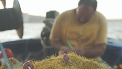 Griechischer-Fischer-Repariert-Netze,-Traditioneller-Fokus-Auf-Netze,-Die-In-Der-Hand-Wackelig-Sind