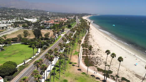 Aerial-shot-over-the-palm-trees-of-Chase-Palm-Park-and-the-sandy-beaches-on-the-Pacific-ocean-in-sunny-Santa-Barbara,-California