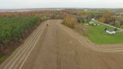 Aerial-drone-footage-flying-backwards-revealing-the-city-around-the-farm-on-harvesting-season