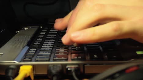 Finger-Tippen-Auf-Einem-Laptop-Mit-Hintergrundbeleuchteter-Tastatur