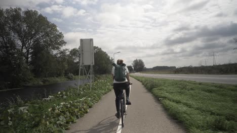 Frau-Radfahren-Auf-Der-Straße-In-Einer-Typischen-Holländischen-Dorflandschaft